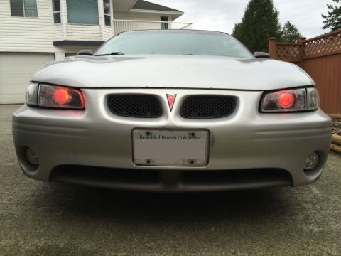 2002 Pontiac Grand Prix - Front view of a silver Pontiac Grand Prix with red halo headlights and a "Beautiful British Columbia" license plate. The car is parked in a…