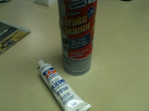 2002 Pontiac Grand Prix - A can of GUNK Pro Series Brake Cleaner and a tube of Permatex Clear Silicone Adhesive Sealant are shown on a speckled countertop next to a…