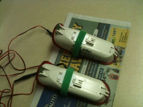 2002 Pontiac Grand Prix - Two white automotive tail light assemblies with red trim are secured with green velcro straps and connected to red and black wires. They ar…