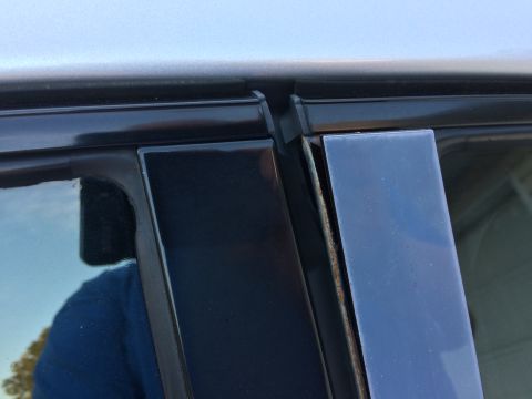 2002 Pontiac Grand Prix - A close-up view shows the black trim and window seal area of a car door, with some rust visible on the inner edge of the trim.