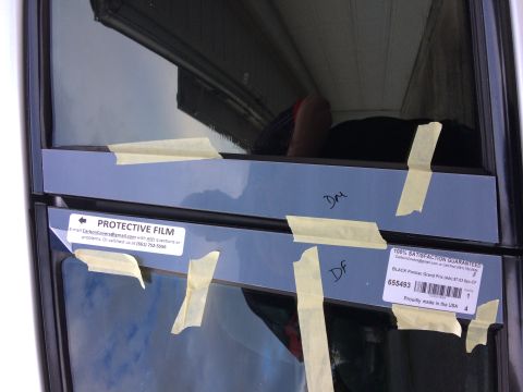 2002 Pontiac Grand Prix - Two pieces of protective film are taped to the exterior of a car window. A label on the lower film reads "100% SATISFACTION GUARANTEED BLAC…