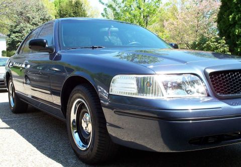 1998 Ford Crown Victoria - Front quarter view of a dark blue 1998 Ford Crown Victoria parked outdoors.