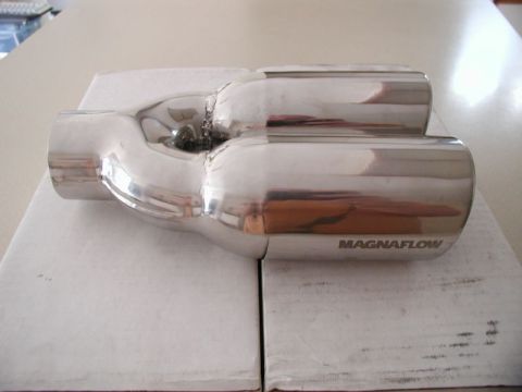 2002 Pontiac Grand Prix - A polished stainless steel Magnaflow exhaust tip with a dual outlet is shown resting on white boxes. The tip has a Y-shaped inlet and two p…