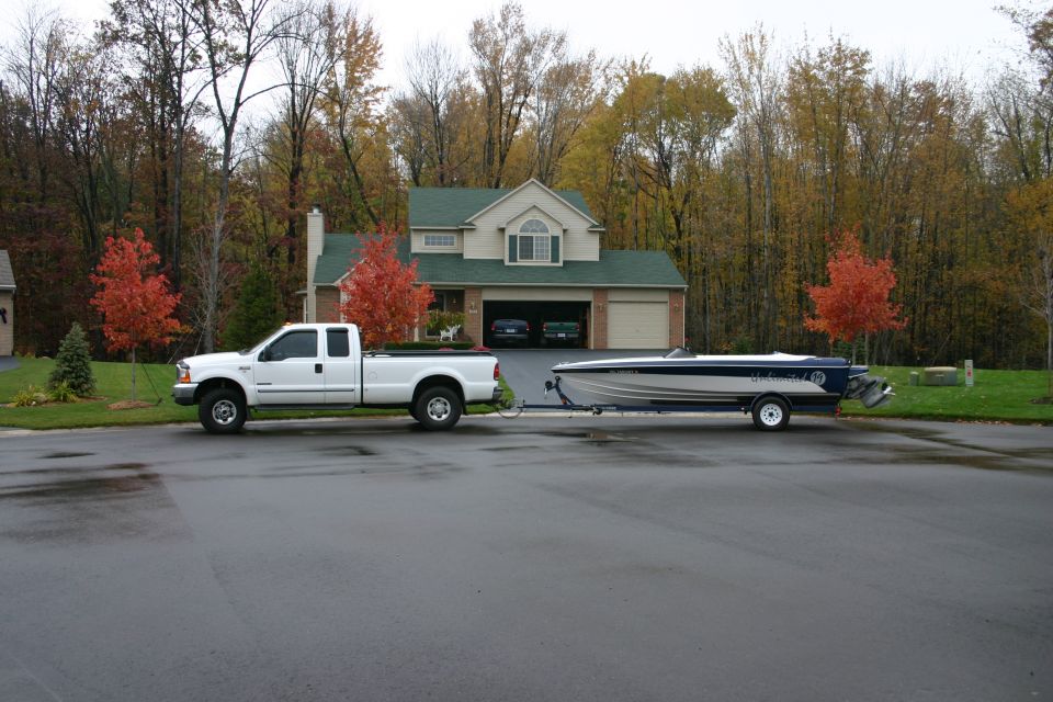 White 1999 Ford F-350 side view towing a boat