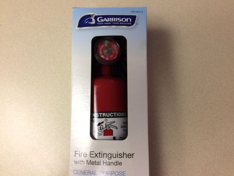 2002 Pontiac Grand Prix - A box containing a red Garrison fire extinguisher with a metal handle and a gauge. The box has instructions and branding visible.