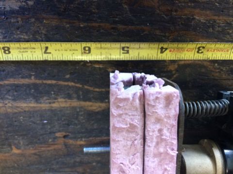 2002 Pontiac Grand Prix - A close-up shot shows a yellow measuring tape with inch and centimeter markings, positioned above a piece of pink, fibrous material held in…