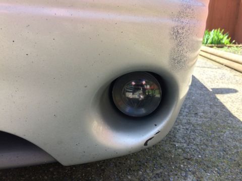2002 Pontiac Grand Prix - A close-up, low-angle shot of the front bumper of a silver car, showing a fog light assembly and some minor paint chips.