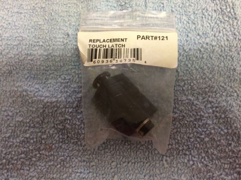 2002 Pontiac Grand Prix - A clear plastic bag contains a black replacement touch latch with a white label that reads "REPLACEMENT TOUCH LATCH" and "PART#121" above a…