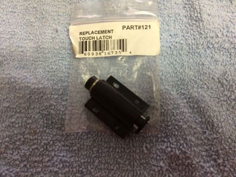 2002 Pontiac Grand Prix - A black replacement touch latch is shown in its original packaging, which has a label that reads "REPLACEMENT TOUCH LATCH PART#121". The it…