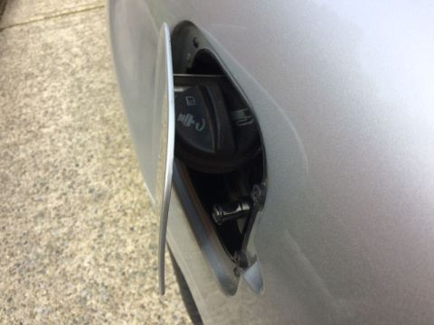 2002 Pontiac Grand Prix - The open fuel filler door on a silver Pontiac Grand Prix reveals the gas cap and surrounding area. The door is slightly ajar, showing the i…