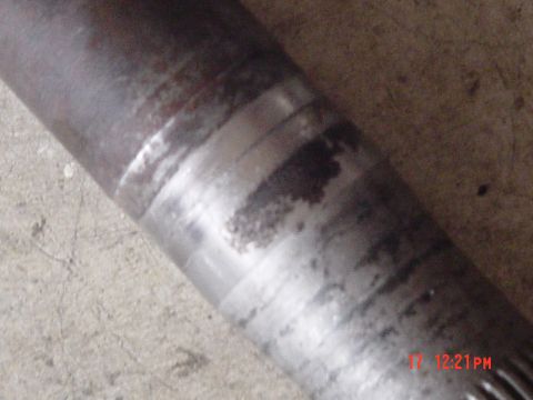 1987 Ford Bronco - Metal shaft with visible wear marks and staining, likely a component from a vehicle.