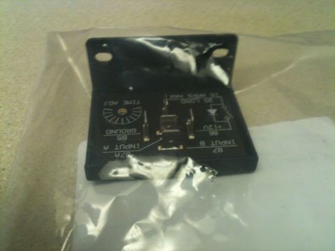 2002 Pontiac Grand Prix - A black automotive relay with labeling for "INPUT A", "GROUND", "TIME ADJ", "INPUT B", and voltage/load specifications is shown in a plasti…