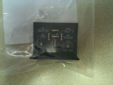 2002 Pontiac Grand Prix - A black automotive relay with labeling for inputs, outputs, ground, and time adjustment is shown in a plastic bag.