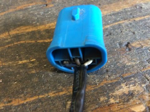 2002 Pontiac Grand Prix - A blue electrical connector with black, white, and brown wires is shown plugged into a black cable with the text "LR03355" printed on it. T…