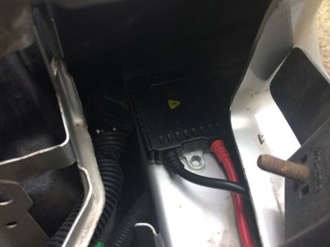 2002 Pontiac Grand Prix - A close-up view shows a black ballast with red and black wires connected to it, mounted inside a vehicle's engine bay.