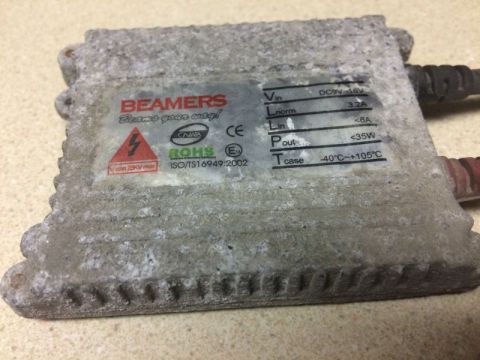 2002 Pontiac Grand Prix - A close-up view of a weathered automotive ballast labeled "BEAMERS". The ballast has visible specifications including input voltage, curren…