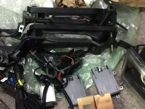 2002 Pontiac Grand Prix - A collection of automotive parts, including a black plastic bracket assembly, wiring harnesses, and two gray electronic control modules, ar…