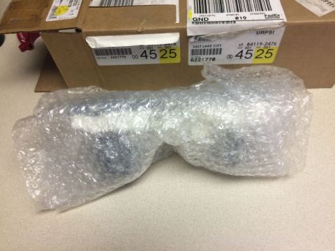 2002 Pontiac Grand Prix - A car part wrapped in bubble wrap sits on a counter in front of a cardboard shipping box with FedEx labels.