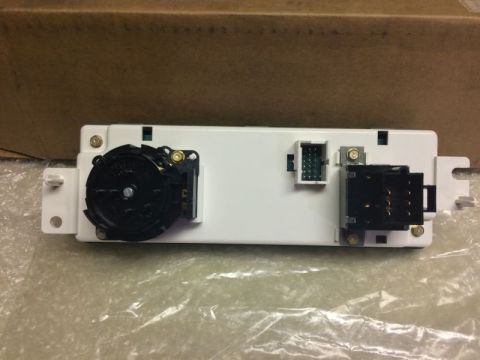 2002 Pontiac Grand Prix - The back of a white electronic control module with three connectors. On the left is a black rotary switch, in the middle is a green connect…