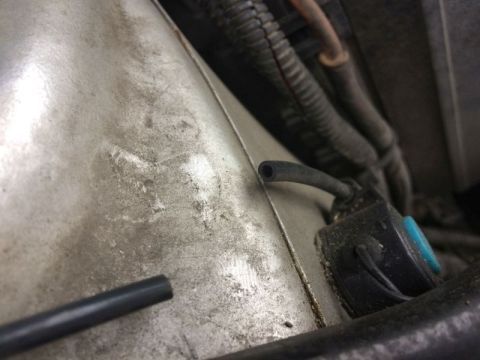 2002 Pontiac Grand Prix - A close-up view of a black vacuum hose connected to a small black and blue electronic component, likely part of an engine system. Another d…