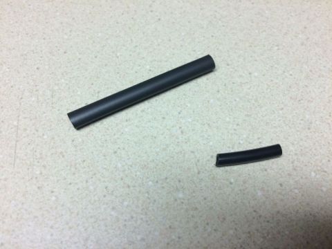 2002 Pontiac Grand Prix - Two pieces of black heat shrink tubing are shown on a speckled countertop.