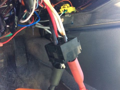 2002 Pontiac Grand Prix - A close-up view of wiring harness and connectors under the dashboard of a vehicle, with a brake pedal visible in the lower left.