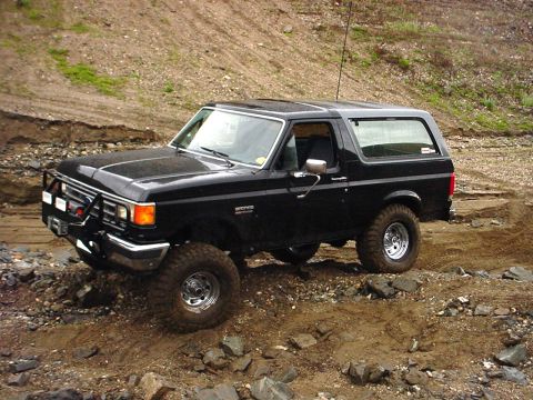 1988 Ford Bronco - This 1988 Ford Bronco is navigating a challenging off-road course with rocky terrain.