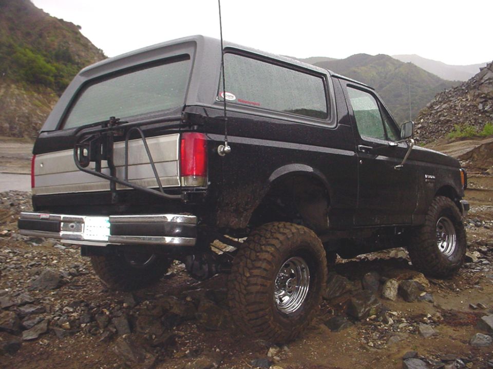 Black Ford Bronco with off-road tires on a rocky trail