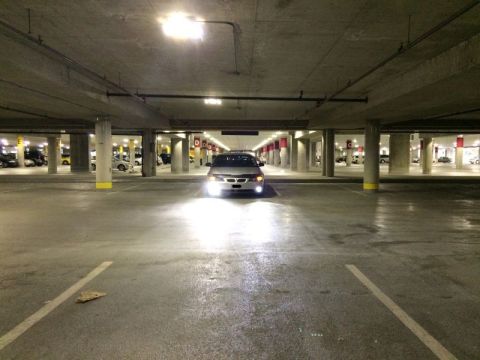 2002 Pontiac Grand Prix - A silver sedan is parked in a brightly lit underground parking garage. The car's headlights are on, illuminating the wet concrete floor.