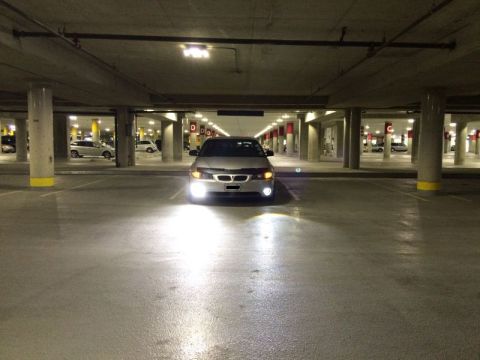 2002 Pontiac Grand Prix - A silver Pontiac Grand Prix is parked in a dimly lit underground parking garage, its headlights illuminated.