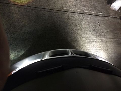 2002 Pontiac Grand Prix - The front of a dark colored vehicle is shown at night, with bright headlights illuminating the asphalt ground. The vehicle has a silver hoo…