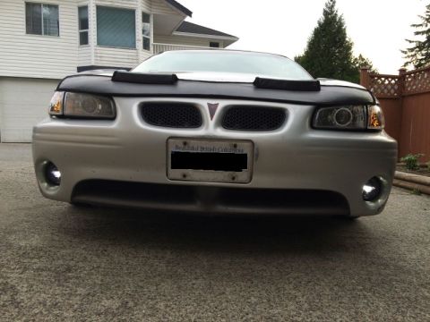 2002 Pontiac Grand Prix - Front view of a silver Pontiac Grand Prix with a black car bra installed. The vehicle has aftermarket halo headlights and fog lights, and a…