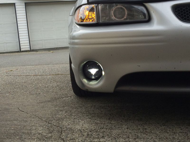 Silver 2002 Pontiac Grand Prix front bumper with illuminated fog light.