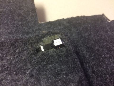 2002 Pontiac Grand Prix - A close-up view of a small, rectangular LED light with a black connector attached to dark gray fabric.