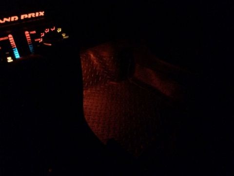 2002 Pontiac Grand Prix - The interior of a car at night shows the illuminated dashboard with the text "GRAND PRIX" visible. A diamond plate floor mat is also visibl…