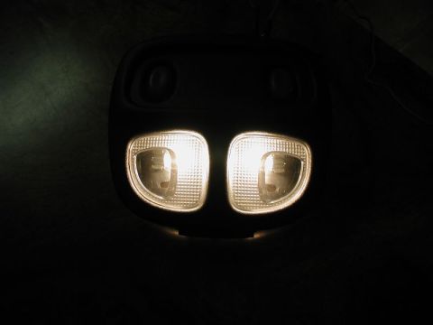 2002 Pontiac Grand Prix - A close-up view of an interior dome light assembly with two illuminated bulbs, likely from a 2002 Pontiac Grand Prix.