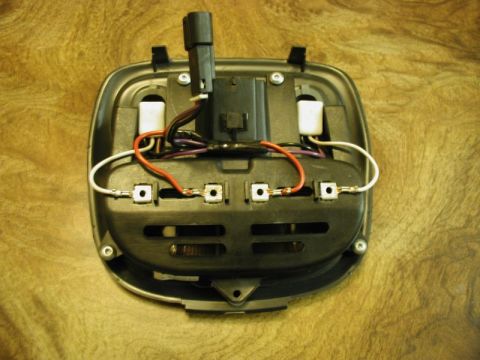 2002 Pontiac Grand Prix - The underside of a black automotive interior light fixture shows wiring, connectors, and a black plastic housing. The fixture is mounted on…