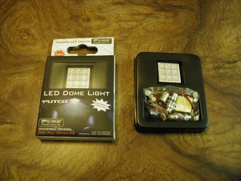 2002 Pontiac Grand Prix - A black box containing a Putco LED dome light kit is shown next to an open black metal case filled with multiple small LED bulbs and wires.