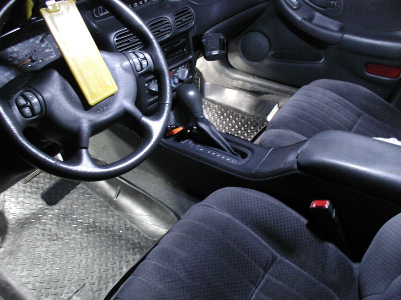 Interior of a Pontiac Grand Prix showing steering wheel, dashboard, seats, and center console.