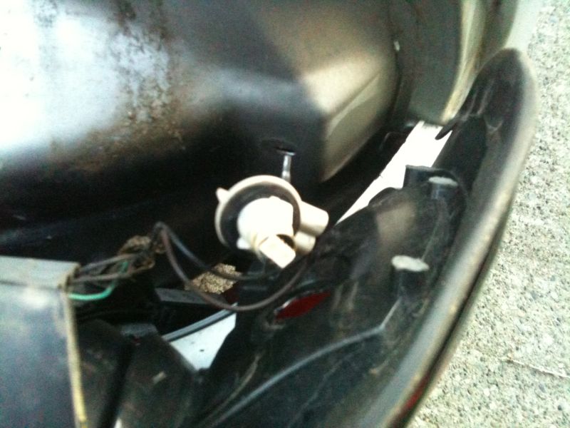 Close-up of a vehicle's taillight assembly interior with wiring and bulb socket.