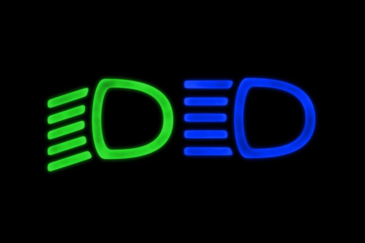 Green and blue headlight symbols on a black background.
