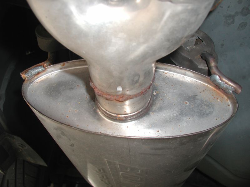 Rusted welds on a vehicle's exhaust system muffler.