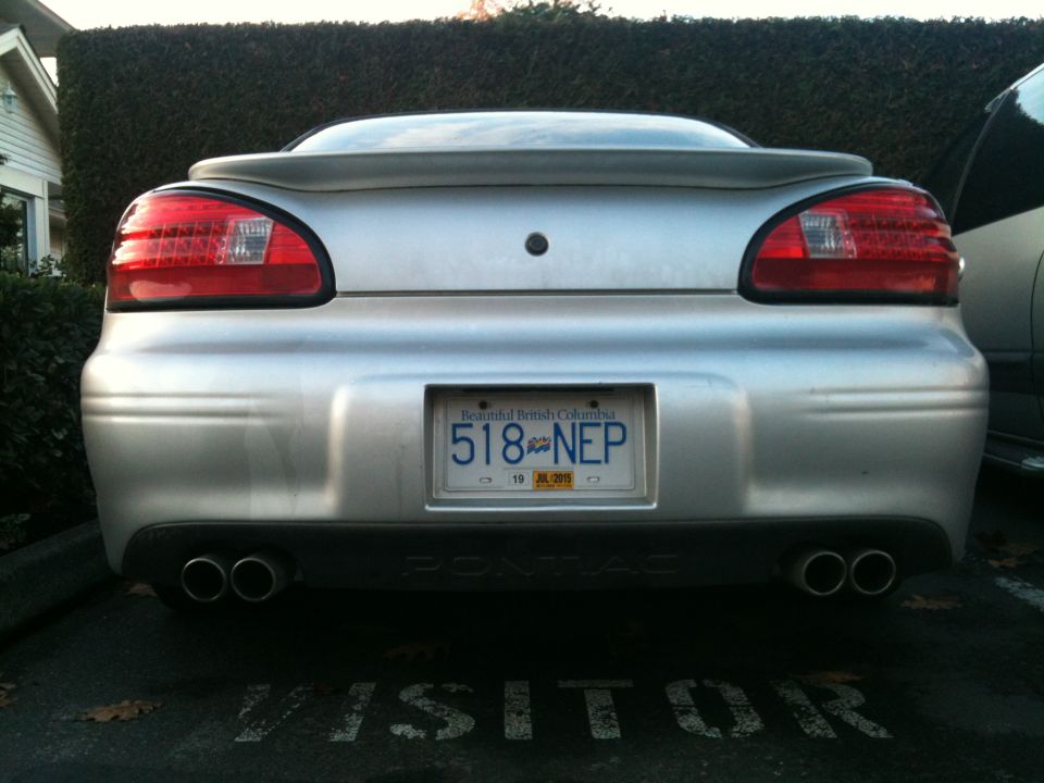 Rear view of a silver 2002 Pontiac Grand Prix with dual exhaust and BC license plate.