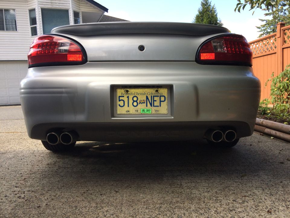 Rear view of a silver 2002 Pontiac Grand Prix with dual exhaust and BC license plate 518 NEP.