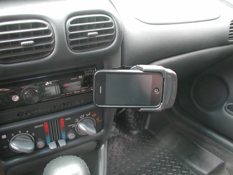 iPhone mounted on car dashboard next to JVC stereo and climate controls.