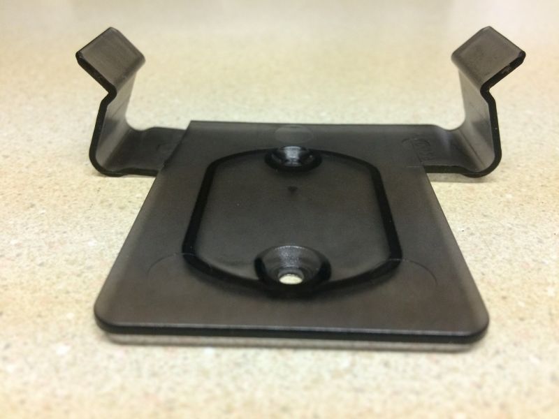Dark plastic bracket with clips and recessed area