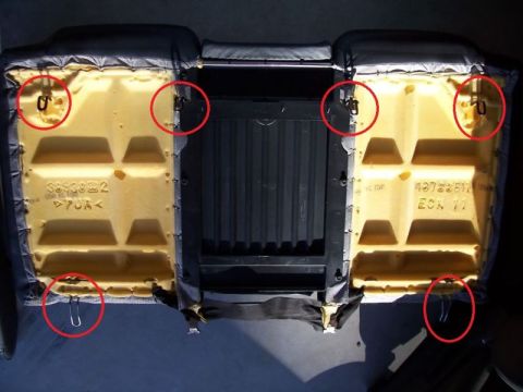 2002 Pontiac Grand Prix - The underside of a car seat cushion is shown, with metal clips circled in red. The seat appears to be from a 2002 Pontiac Grand Prix.