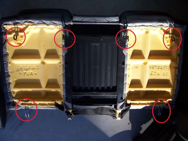 Underside of a car seat cushion with metal clips circled in red.