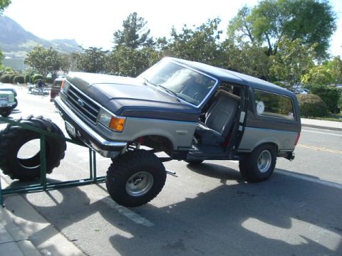 1989 Ford Bronco - This lifted Ford Bronco is displayed on a metal stand, its off-road tires.