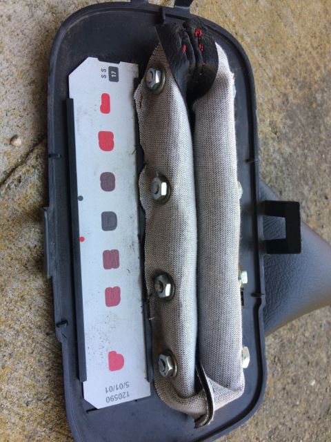 2002 Pontiac Grand Prix - A deployed airbag module is shown, with the fabric bag partially inflated and secured by bolts. A white label with red and gray squares and…